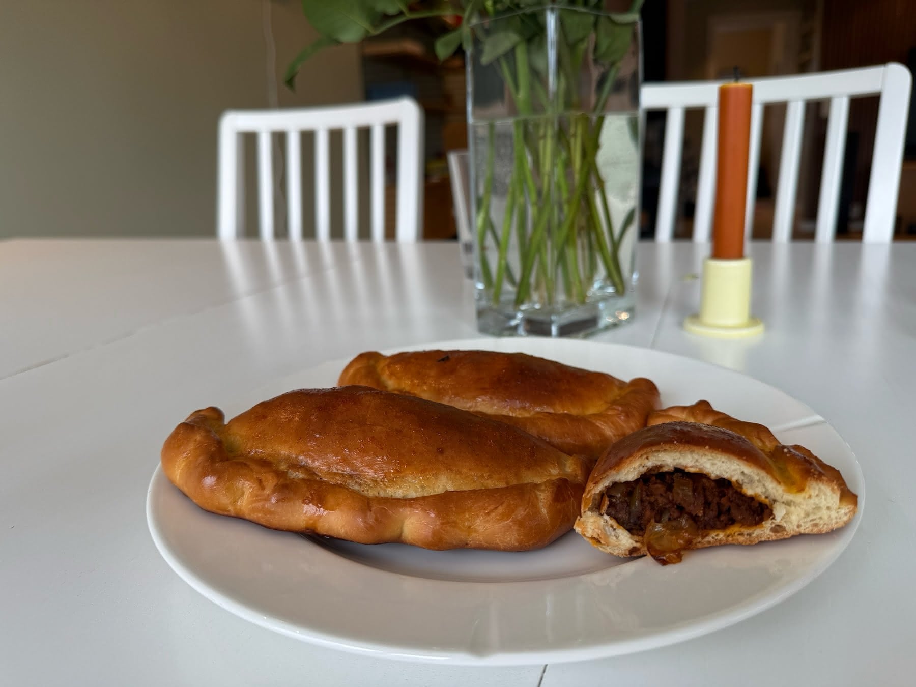Ovnsbakte piecuchy med kjøttfyll på en tallerken, en av dem delt så fyllet synes